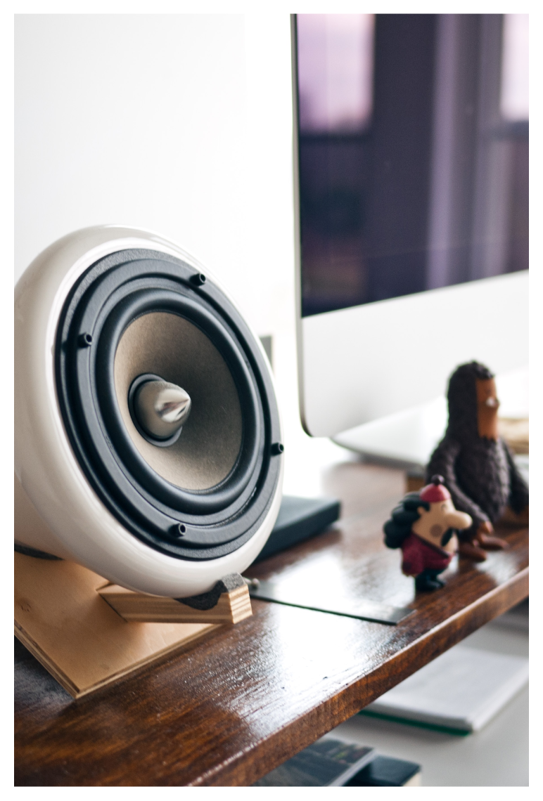 Speaker on a desk next to a computer